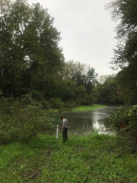 A Natural Resource Specialist checks water levels at river oxbows below Saylorville Dam. Improvements to this 3,100 acre area will restore vital seasonal conditions for fish and amphibians in spring and for waterfowl in late summer and fall.