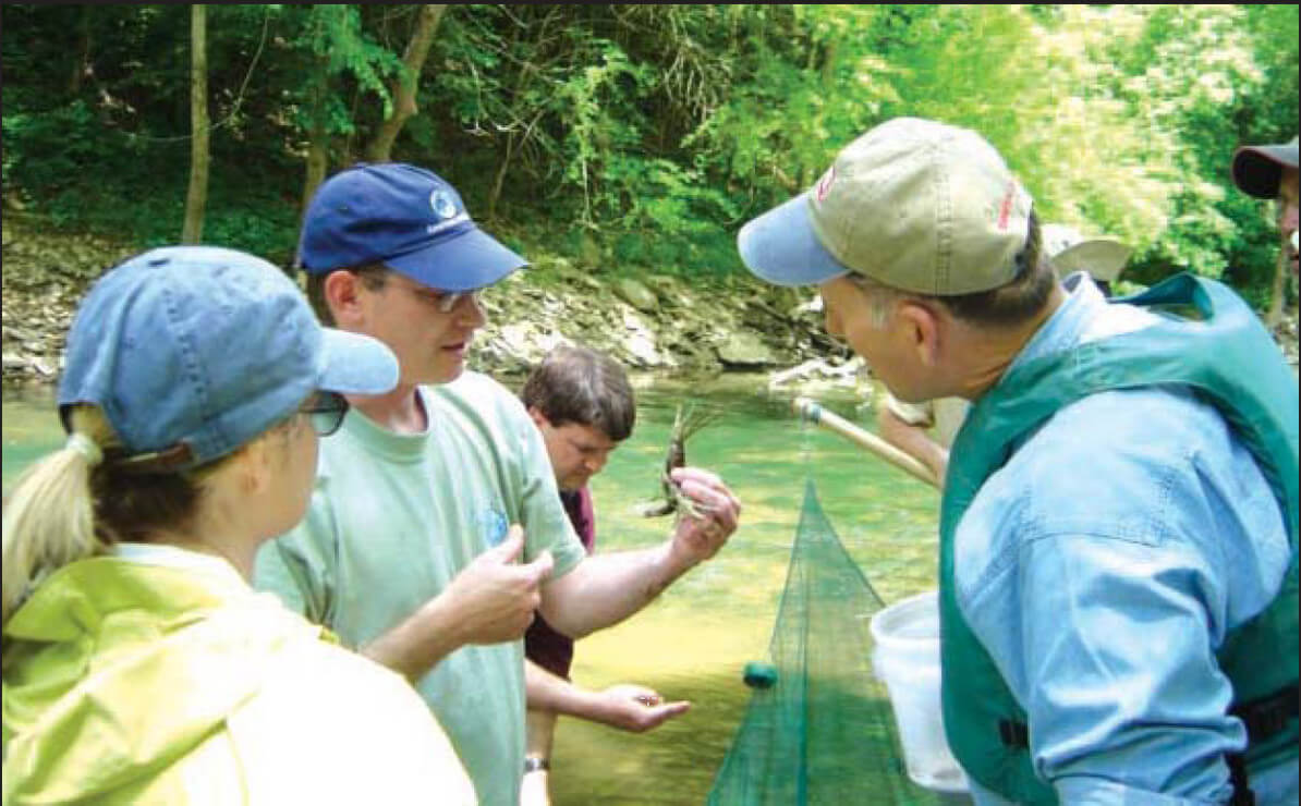 Dr. Richie Kessler, formerly with The Nature Conservancy, shows a bottlebrush crayfish to Lisa Morales, Corps, and John Paul Woodley, Jr., then Assistant Secretary of the Army for Civil Works, during a visit to Green River.